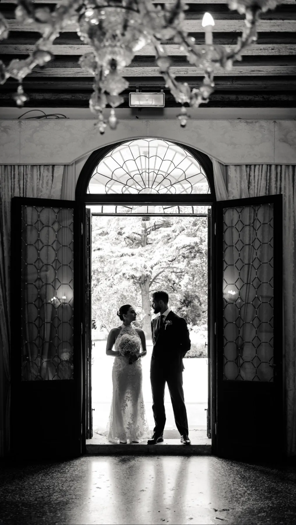 Newlyweds backlit in a Padua villa, black-and-white photograph