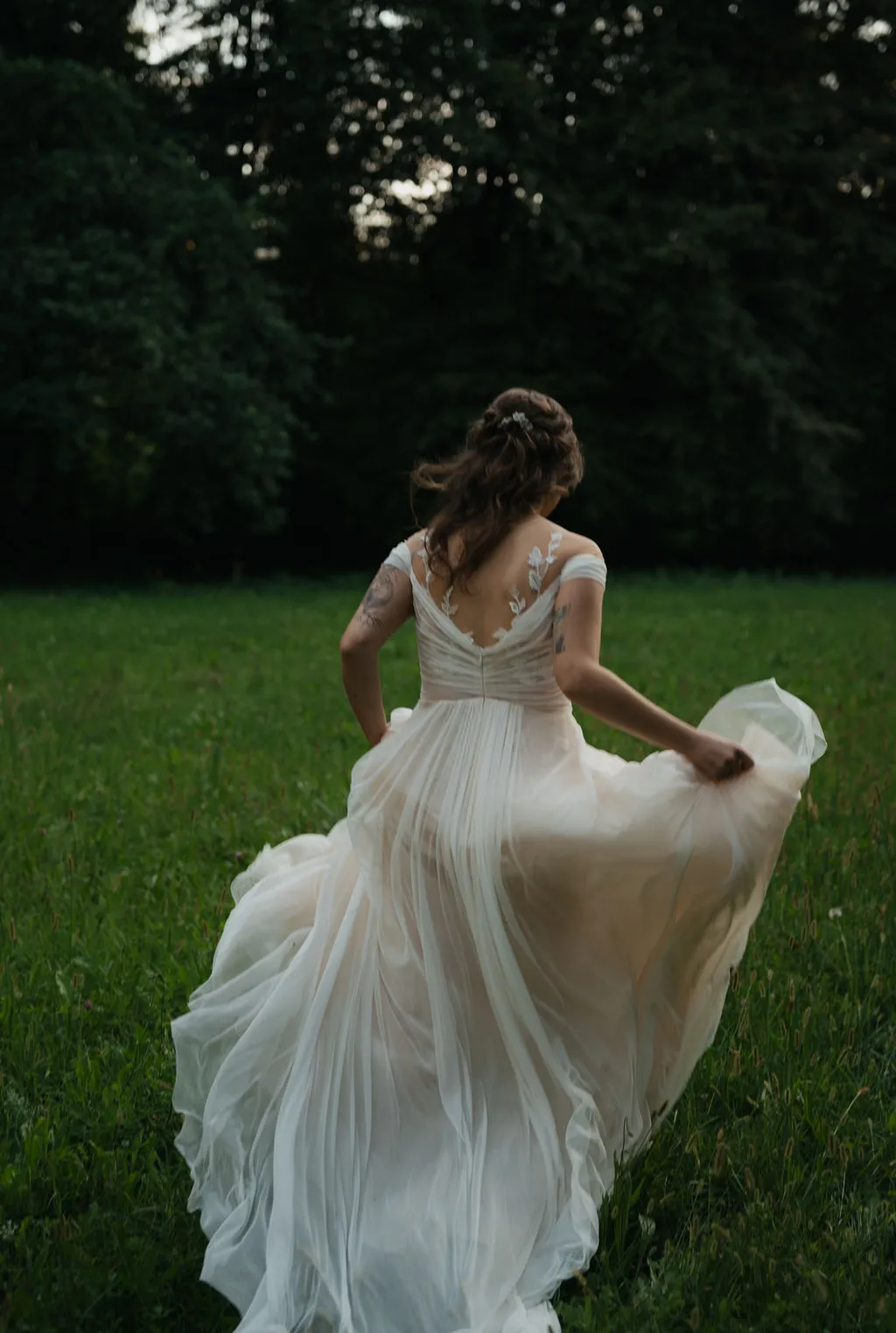Sposa che corre in un prato con l'abito da sposa in movimento, matrimonio nel Veneto