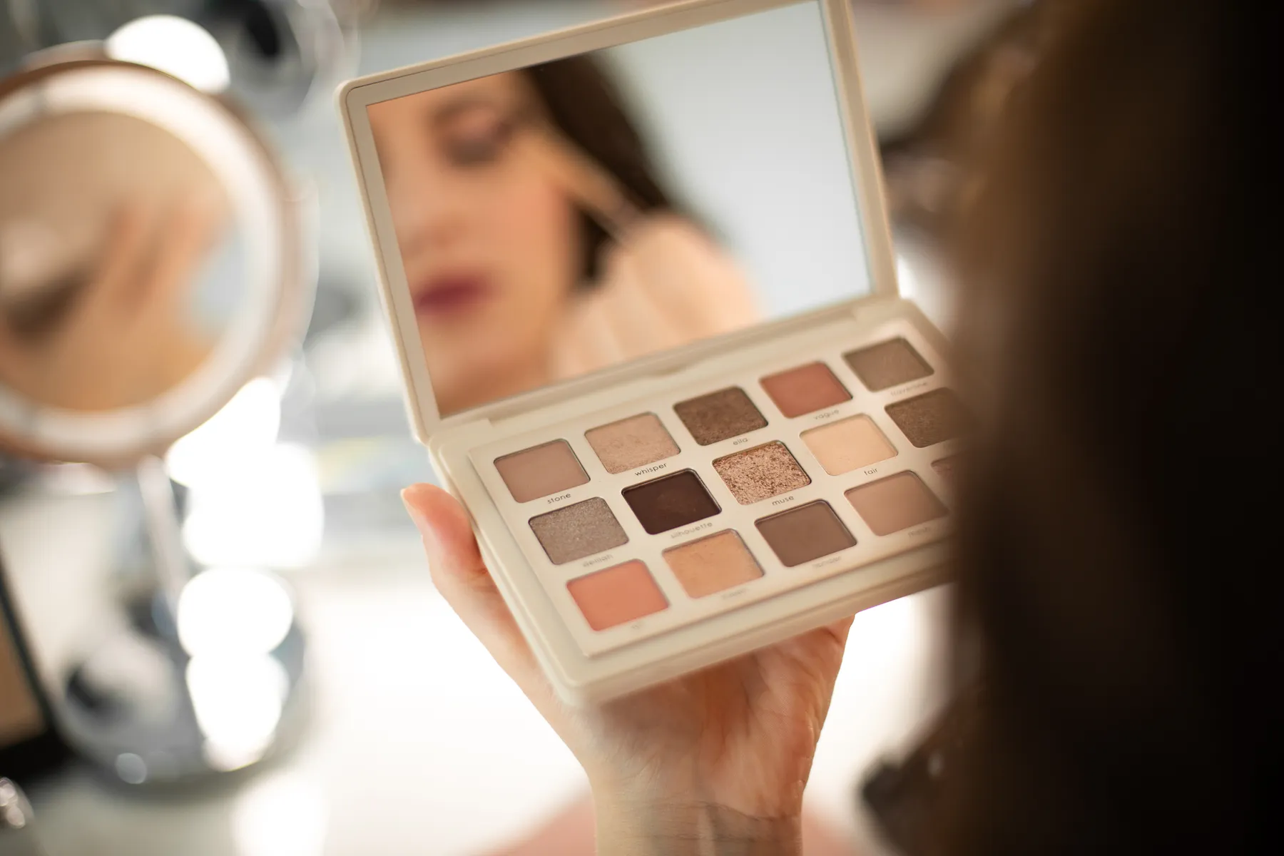 Lezioni di self makeup a Padova: palette di ombretti neutri davanti allo specchio