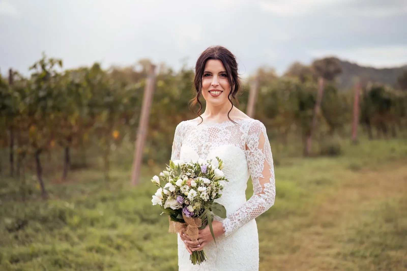 Bride with her bouquet among the vineyards of Veneto
