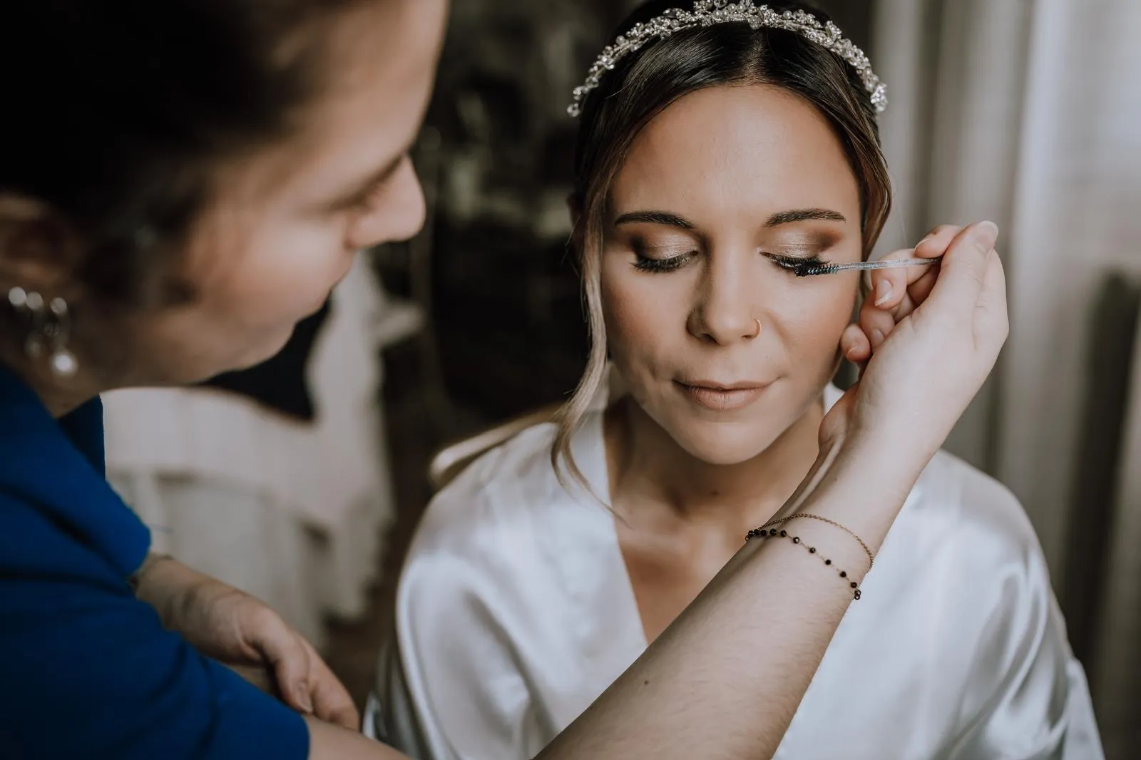 Bridal makeup detail in Venice as the bride puts on her earrings